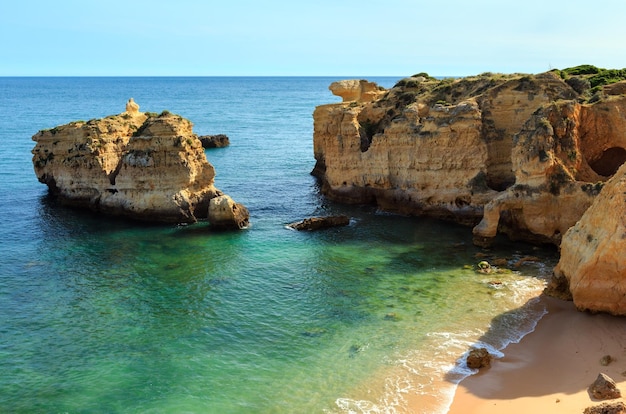 Noite de verão vista da costa rochosa do Atlântico e praia arenosa Praia de San Rafael com falésias calcárias, Albufeira, Algarve, Portugal).