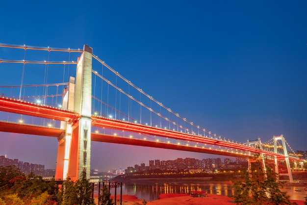 À noite, duas pontes suspensas no rio Yangtze, Chongqing, China