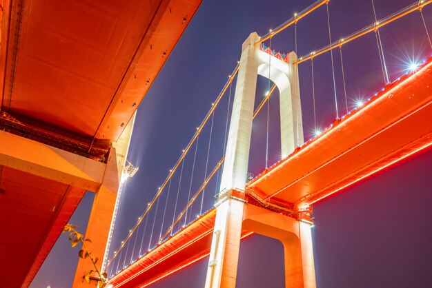 À noite, duas pontes suspensas no rio Yangtze, Chongqing, China