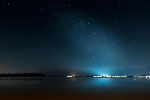 Noite em Bodensee Alemanha com céu estrelado e luz da cidade brilhando na água