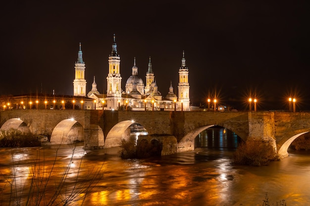 Noite na puente de piedra ao lado da basílica de nossa senhora do pilar