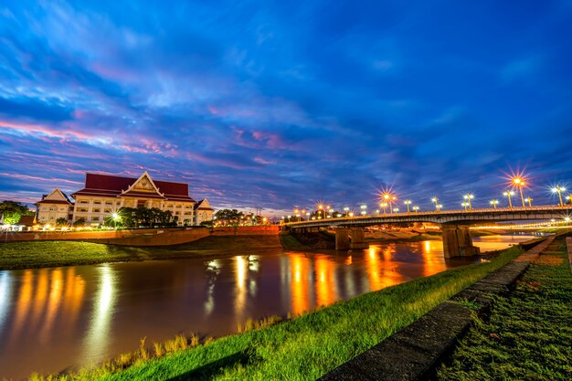 Noite natural na vista do rio Nan e da ponte Naresuan no parque para relaxar, caminhar, correr e se exercitar ao pôr do sol na cidade de Phitsanulok, Tailândia.
