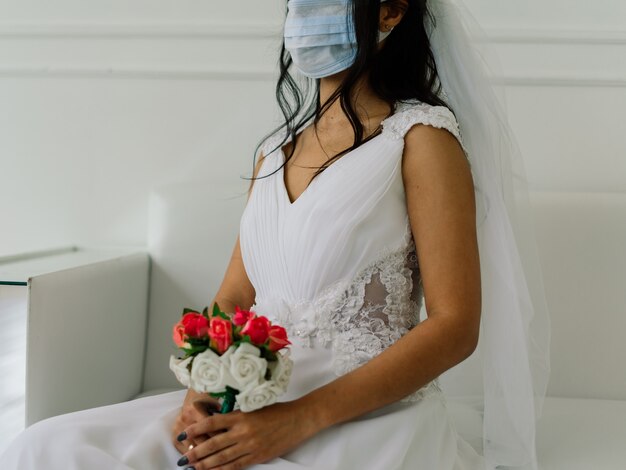 Noiva afro-americana de vestido, máscara e pela manhã se preparando para o casamento em quarto de hotel