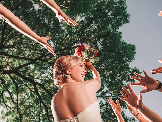 Noiva alegre joga um buquê de casamento para seus amigos. feriados e tradições