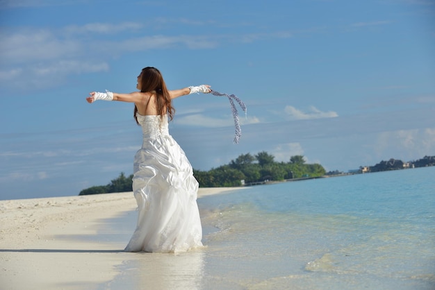 noiva asiática com um véu na praia no céu e mar azul. lua de mel na ilha fantástica no verão