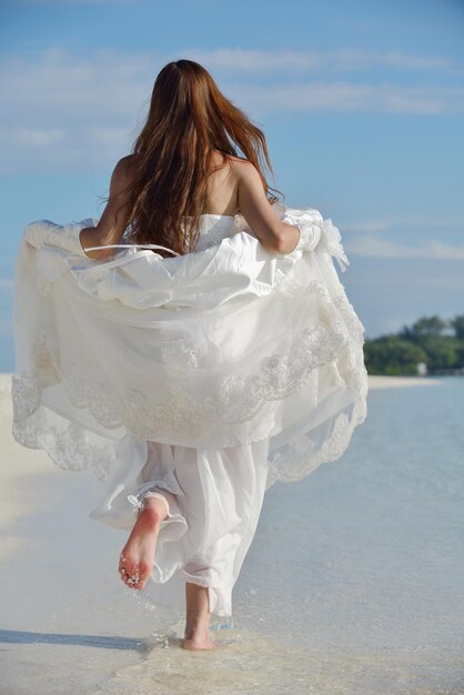 noiva asiática com um véu na praia no céu e mar azul. lua de mel na ilha fantástica no verão