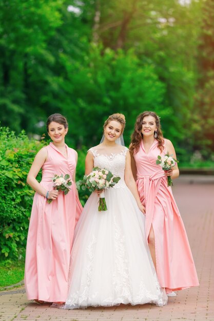 Noiva com damas de honra no parque no dia do casamento meninas hol