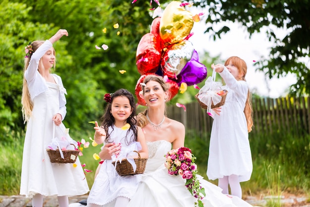 Noiva com meninas como damas de honra, flores e balões