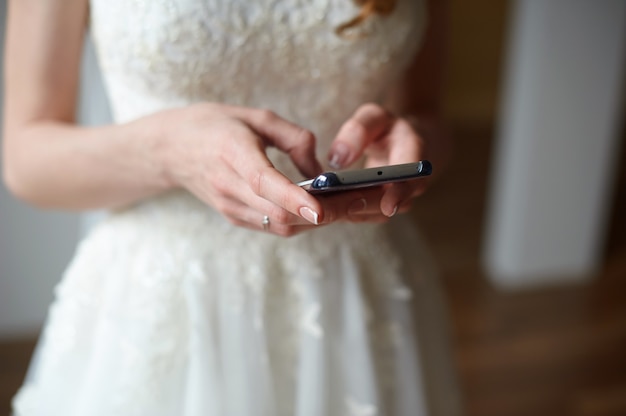 Noiva com o telefone nas mãos dela está digitando uma mensagem.