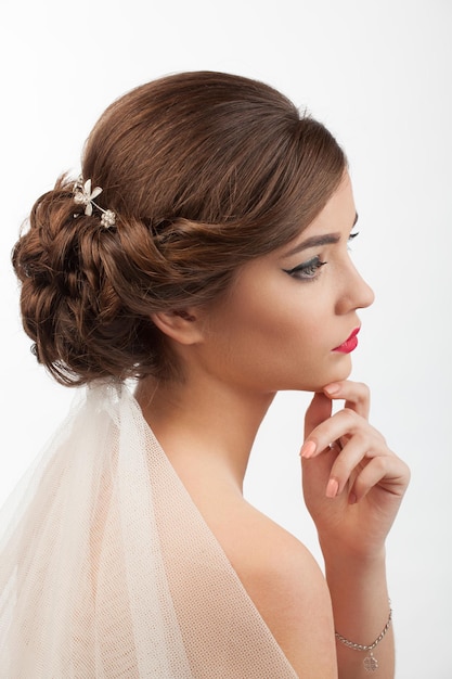 Noiva com penteado de casamento e véu em um fundo branco