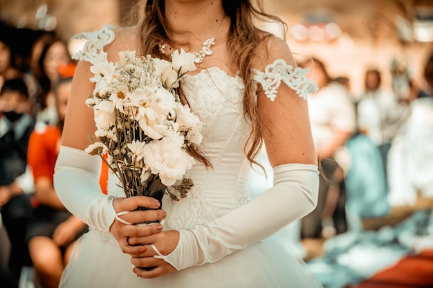 Noiva com um buquê de flores e vestido de noiva natureza e casamento