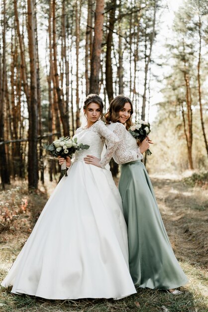 Noiva concurso com damas de honra sorridentes vestidas em vestidos longos e elegantes, damas de honra com noiva feliz no dia do casamento. buquês de casamento são mantidos por namoradas, dia do casamento,