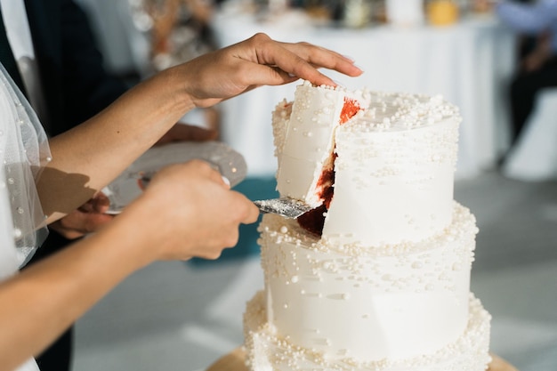 Noiva corta primeiro pedaço do bolo de casamento