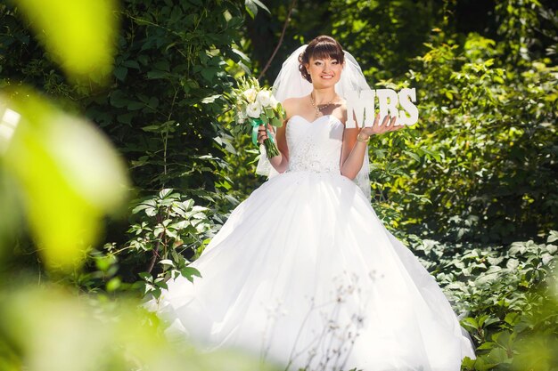 Noiva de beleza na floresta de verão com sinal MRS