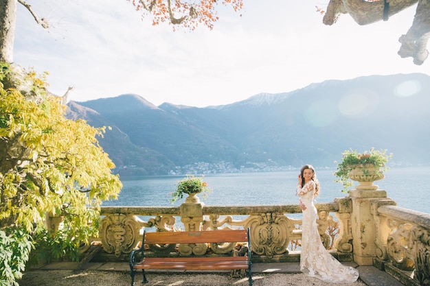 Noiva de casamento com véu e vestido de noiva branco na villa Balbianello lago Como na Itália