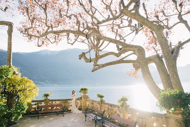 Noiva de casamento com véu e vestido de noiva branco na villa Balbianello lago Como na Itália