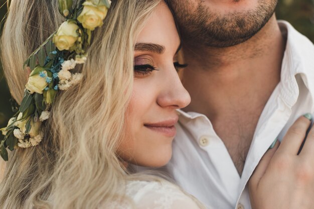 Noiva de vestido branco e grinalda e retrato do noivo em dia ensolarado de verão. Casamento rústico ao ar livre