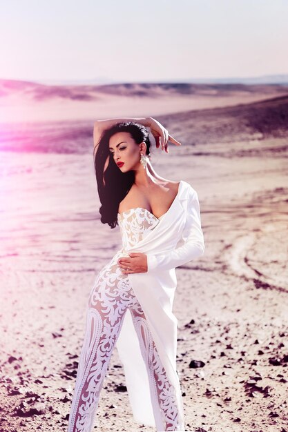 Noiva e cerimônia de casamento. Moda para casamento e salão de beleza. Elegância e modelo de moda. Mulher de vestido branco nas dunas de areia. Garota de vestido no deserto ensolarado.