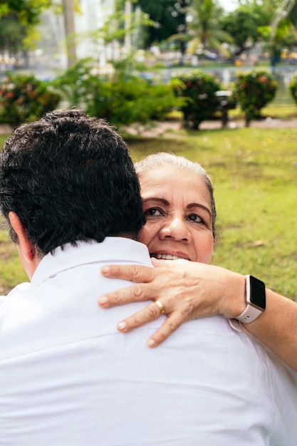 Noiva e noivo abraçando ao ar livre sorrindo vista traseira