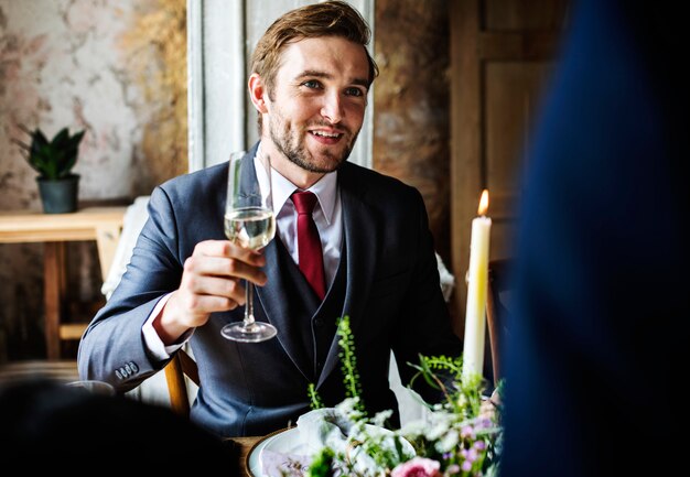 Noiva e noivo agarrando Wineglasses com amigos na recepção de casamento