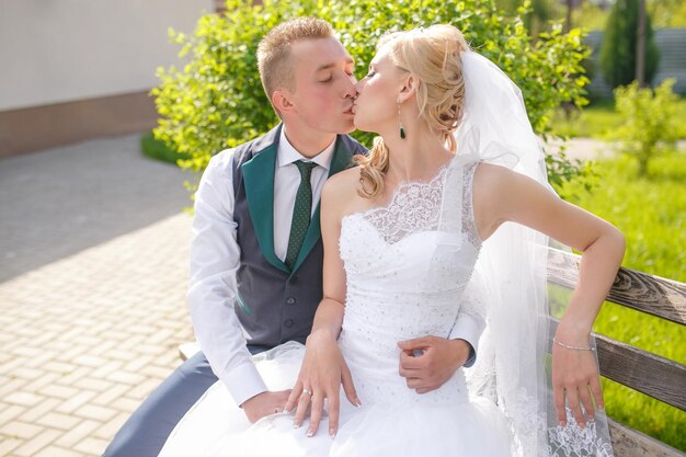 Noiva e noivo beijando no parque
