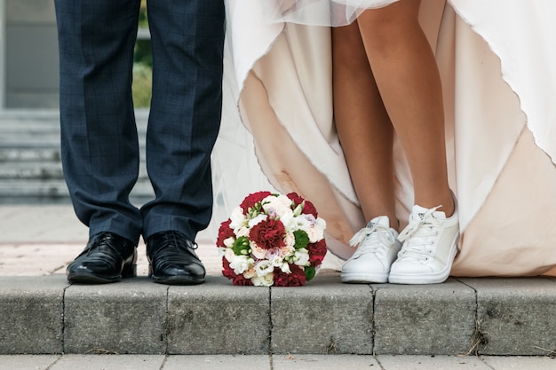 Foto noiva e noivo buquê no chão. casamento, relações familiares, apetrechos de casamento.