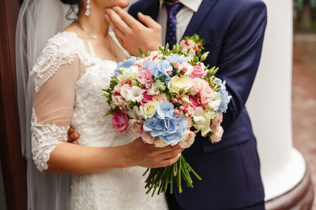 Noiva e noivo com buquê de casamento colorido