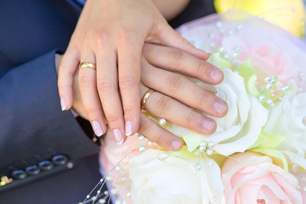 Noiva e noivo de mãos dadas com um buquê