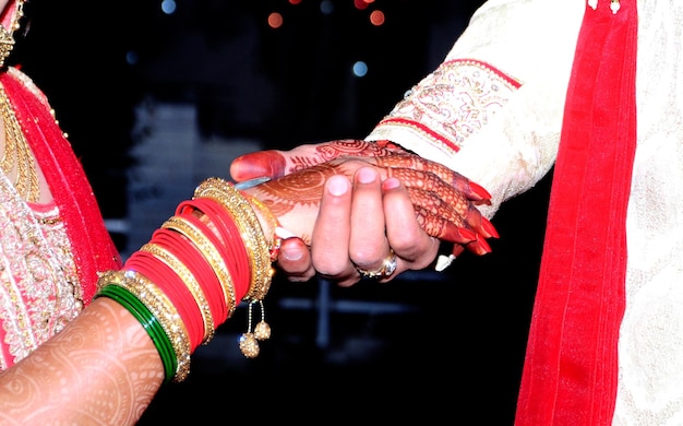 Noiva e noivo de mãos dadas em casamento indiano