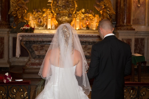 Noiva e noivo durante a cerimônia de casamento na igreja