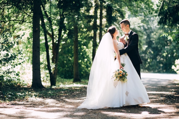 Foto noiva e noivo elegantes posando juntos ao ar livre no dia do casamento