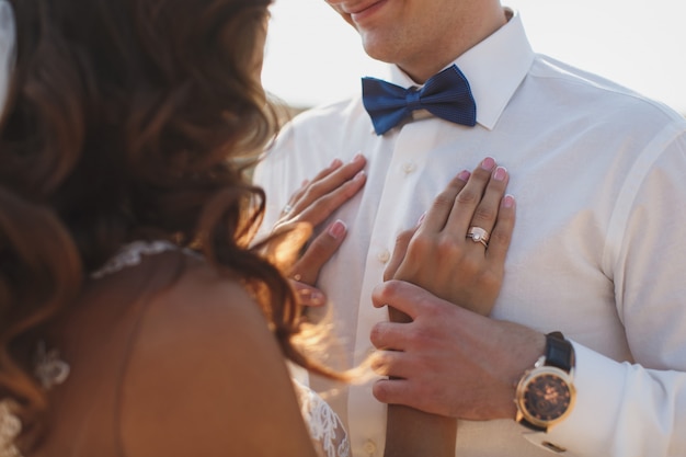 Noiva e noivo felizes em seu casamento abraçando