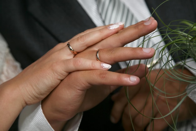 Noiva e noivo mostrando as mãos usando alianças de casamento