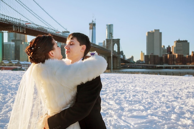 Noiva e noivo no fundo da ponte do Brooklyn