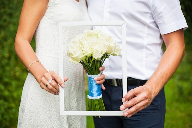 Noiva e noivo segurando um lindo buquê de casamento