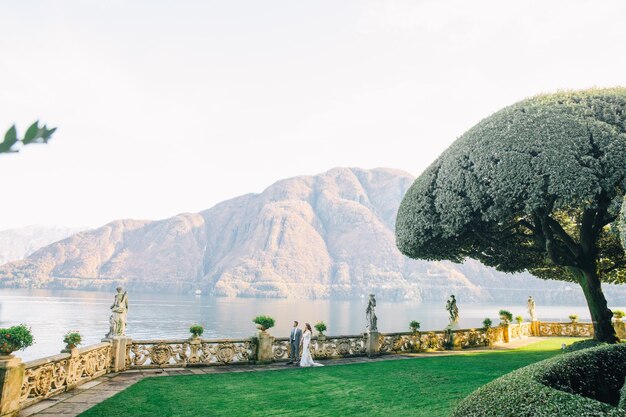 noiva e noivo véu longo e vestido branco no fundo das montanhas lago Como Itália