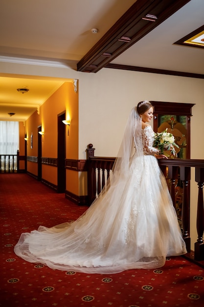 Noiva em um lindo vestido branco no dia do casamento com um buquê nas mãos
