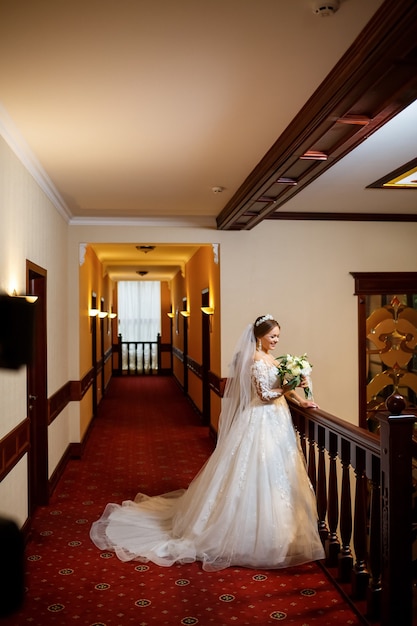 Noiva em um lindo vestido branco no dia do casamento com um buquê nas mãos