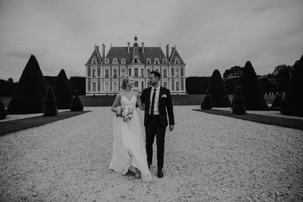 Noiva em um lindo vestido de noiva, noivo em um elegante smoking, vá para o antigo castelo na França