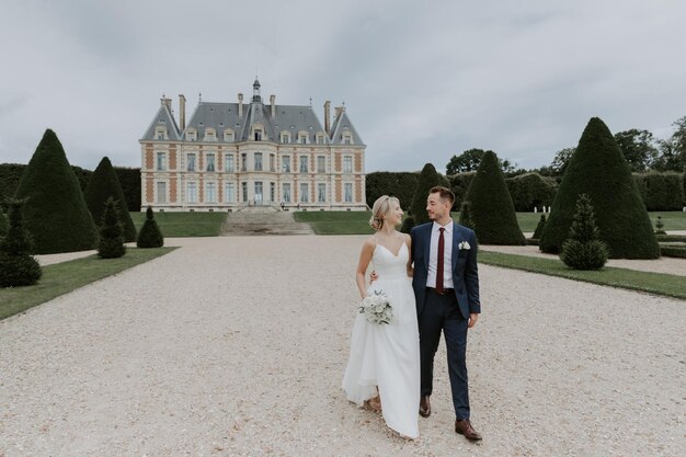 Noiva em um lindo vestido de noiva, noivo em um elegante smoking, vá para o antigo castelo na França