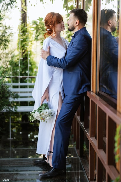 Noiva em um vestido branco com um buquê e o noivo em um terno azul