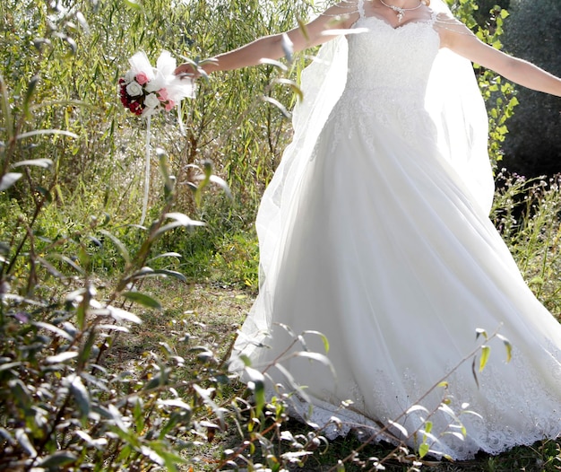 Noiva em vestido de noiva branco com bordado de renda um buquê de flores nas mãos da noiva