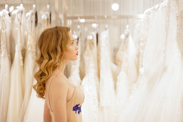 Noiva escolhe um vestido de noiva na loja.