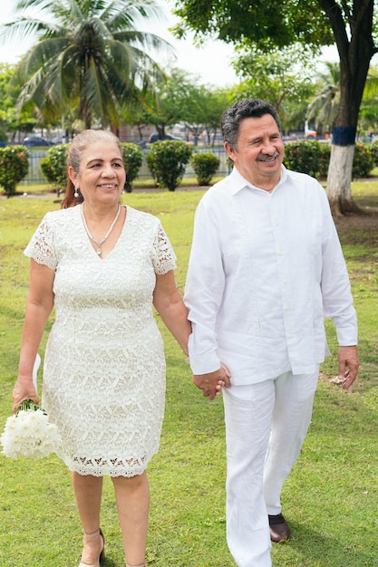 Noiva hispânica segura um lindo buquê de flores brancas recém-casados no dia do casamento