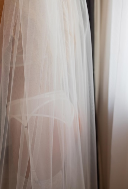 Noiva irreconhecível em um roupão de seda com lindas pernas finas está colocando meias Preparação da manhã do casamento Vestir lingerie boudoir