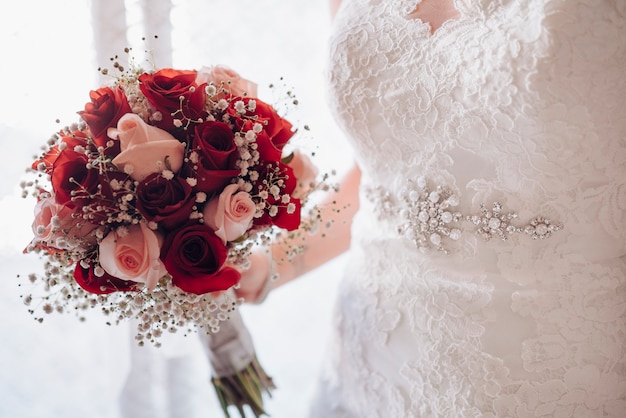 Foto noiva irreconhecível segurando seu buquê de flores no dia do casamento