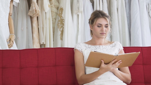 Noiva lendo livro ou catálogo no estúdio de casamento.