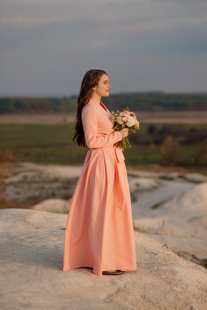 Foto noiva linda com buquê de flores do casamento, mulher atraente vestido de noiva. feliz mulher recém-casada. noiva com penteado e maquiagem de casamento. noiva sorridente. dia do casamento. noiva linda. casamento.