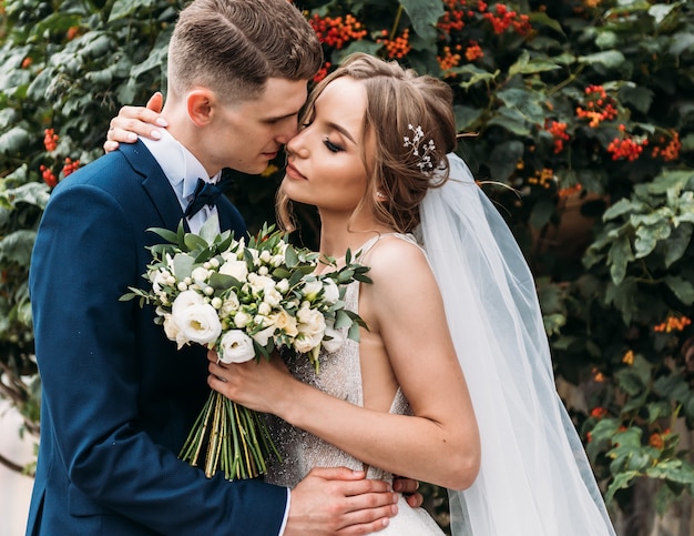 Noiva linda e elegante noivo gentilmente abraçando e sorrindo. casal sensual casamento abraçando. momentos românticos dos noivos.