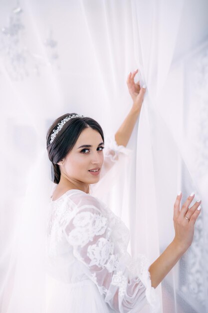 Noiva linda em um vestido elegante em uma manhã de quarto de hotel antes dos preparativos do casamento